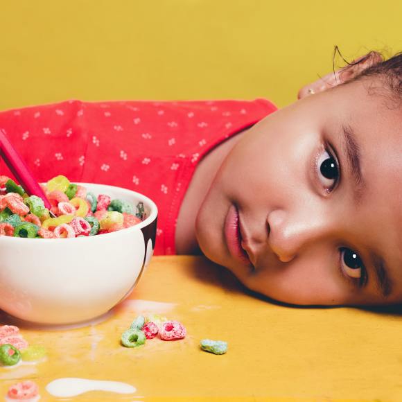 Child looking upset with head down on the table with cereal bowl close by. Fidgets can help with anxiety